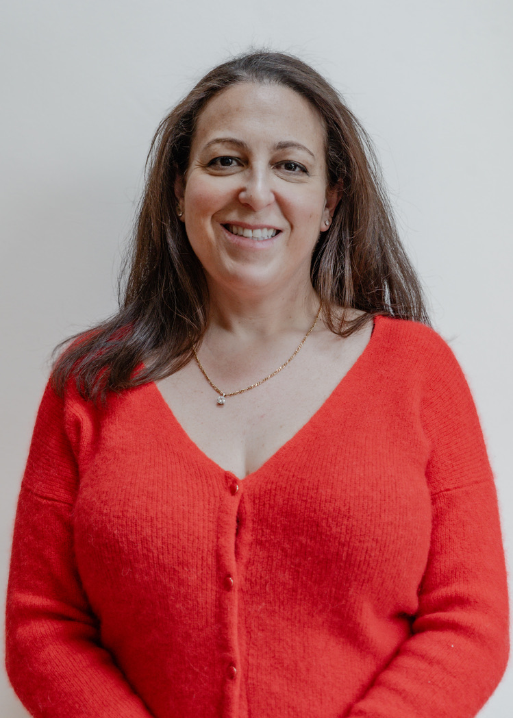 Hannah Cohen, founder of The Insight Coach, smiling in a red cardigan